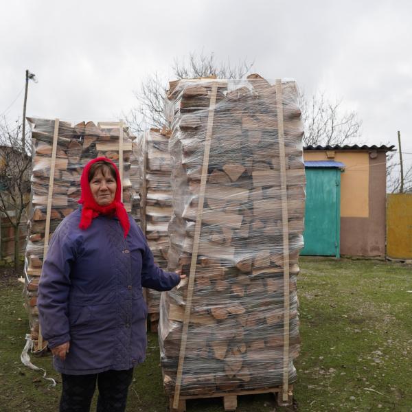 Woman standing with logs 